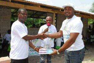 Volunteers and beneficiaries smiling at Lagos Food Bank Initiative, showcasing community support.